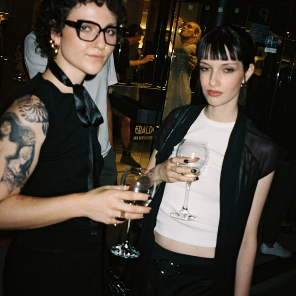 Two guests enjoying drinks during the Ann Demeulemeester AW25 event at Eraldo Store Jesolo.