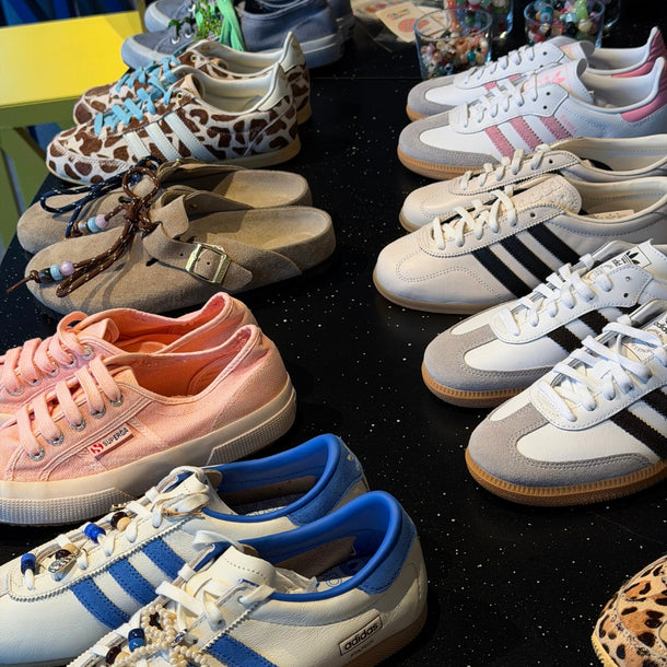 Selection of sneakers, including customized and ready-to-customize pairs, displayed on the table during the Eraldo x Collanine Colorate workshop in 2026.