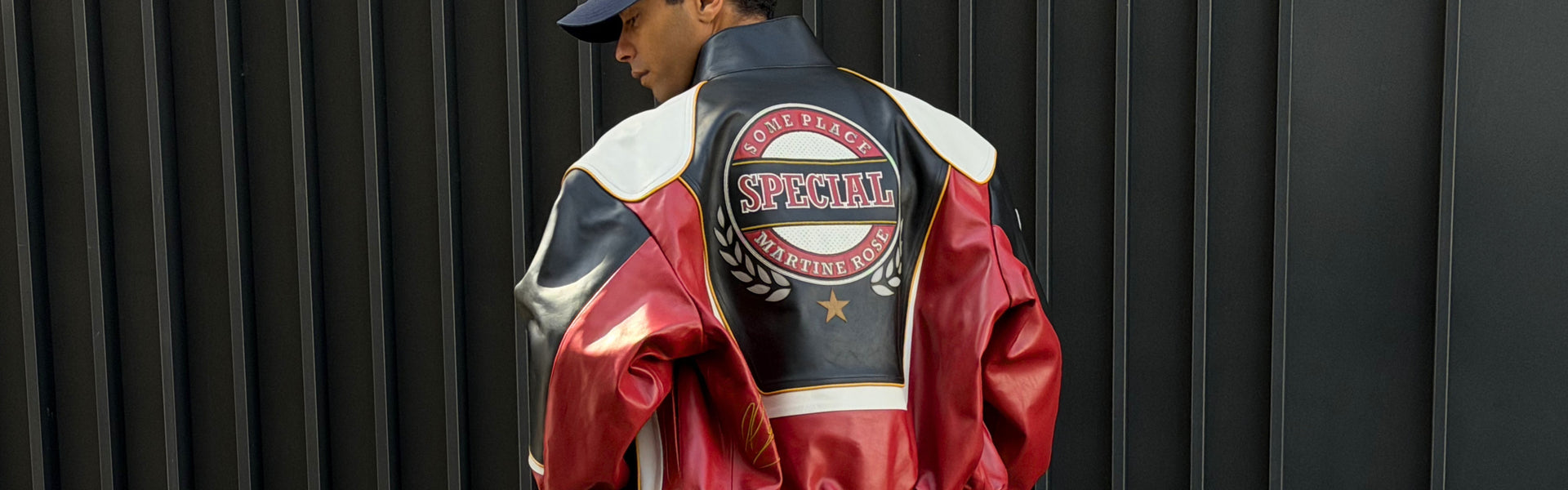 Man wearing a black, red and white leather jacket by Martine Rose