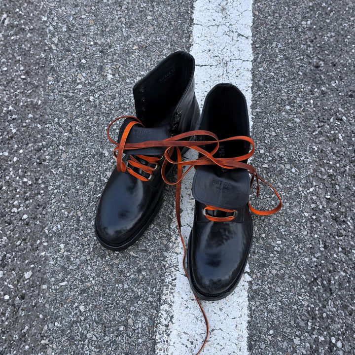 Prada black leather lace-up boots with orange laces.