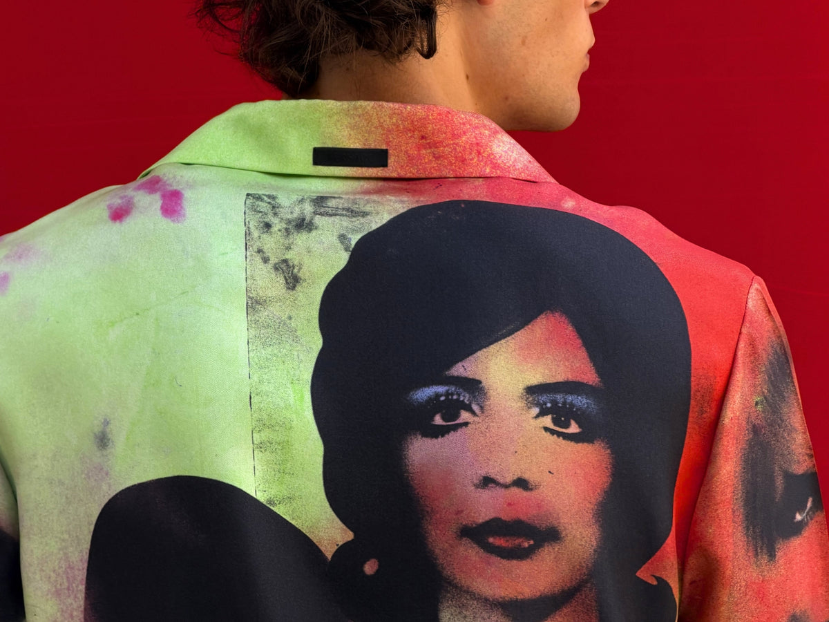 Man wearing a multicolor printed silk shirt by Versace with red, green, blue and purple tones and figurative artwork print