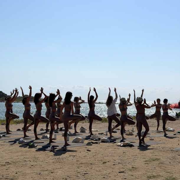 The Andamane AW26 A Morning by the Sea event at Eraldo Store Jesolo, featuring guests practicing beach yoga by the sea.