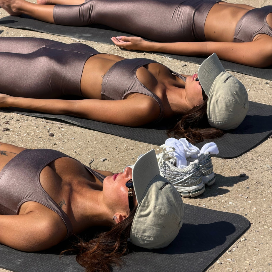Participants lying on the beach after a yoga session, wearing The Andamane branded activewear during the AW26 A Morning by the Sea event at Eraldo Store Jesolo.
