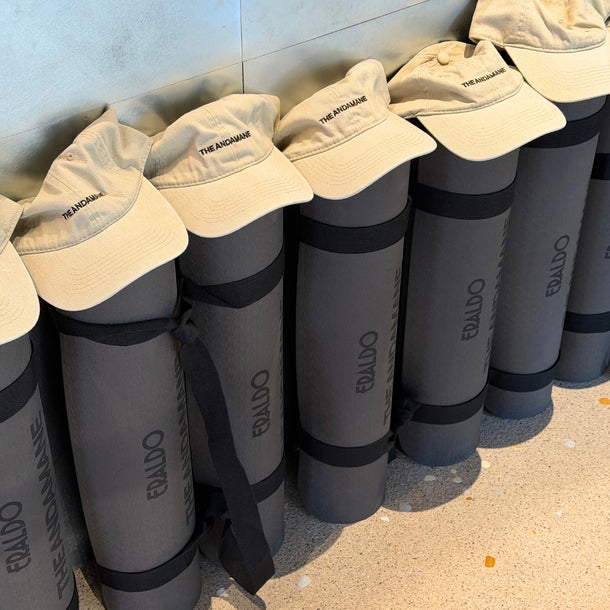 Eraldo x The Andamane branded yoga mats and a The Andamane cap prepared for the AW26 A Morning by the Sea yoga event at Eraldo Store Jesolo.