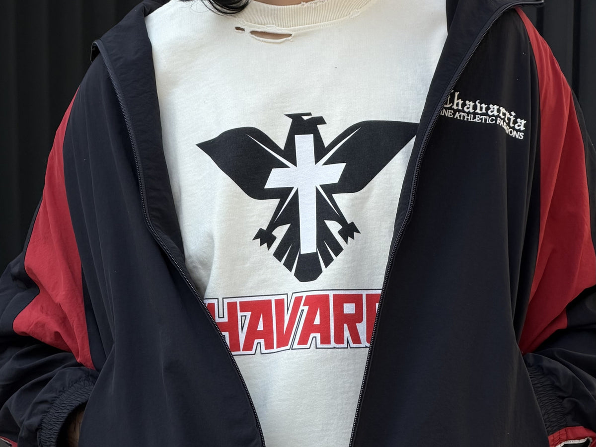 Man wearing Willy Chavarria graphic t-shirt with eagle logo under black and red jacket